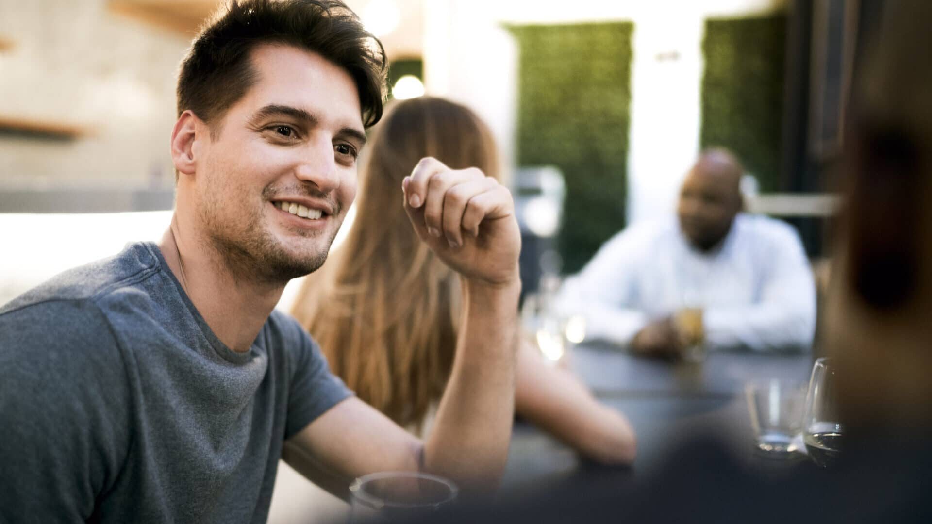 Young man talking with friend in restaurant