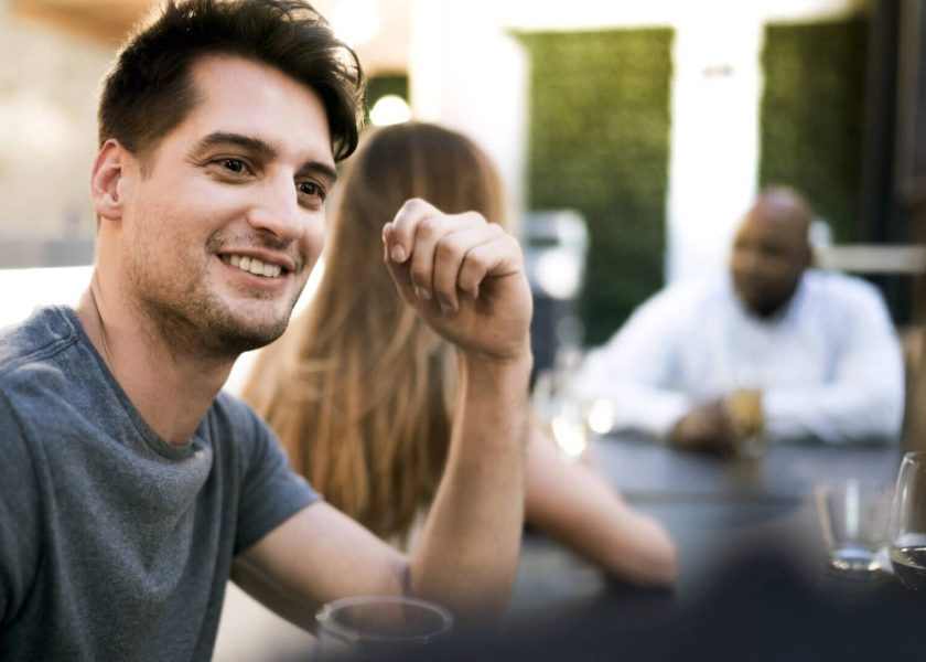 Young man talking with friend in restaurant