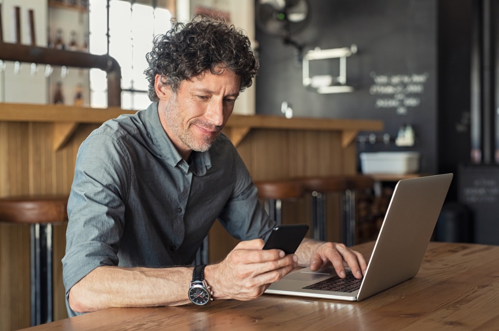 mature-businessman-working-at-cafe-picture-id1040303698