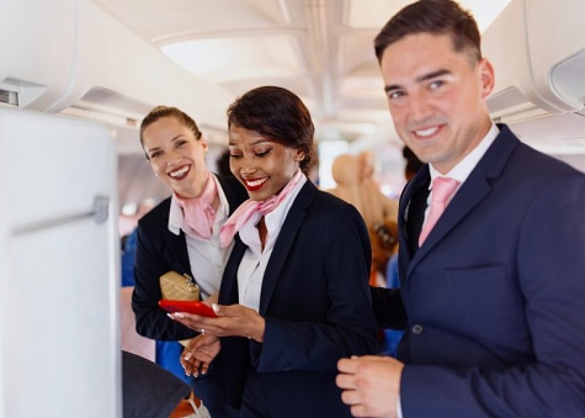 Smiling flight attendants looking at camera during disembarking